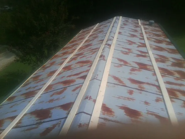Rusted metal roof panels with new wood purlins before replacement — Storm Damage Roof Repair in Ozark by Roofing Brothers