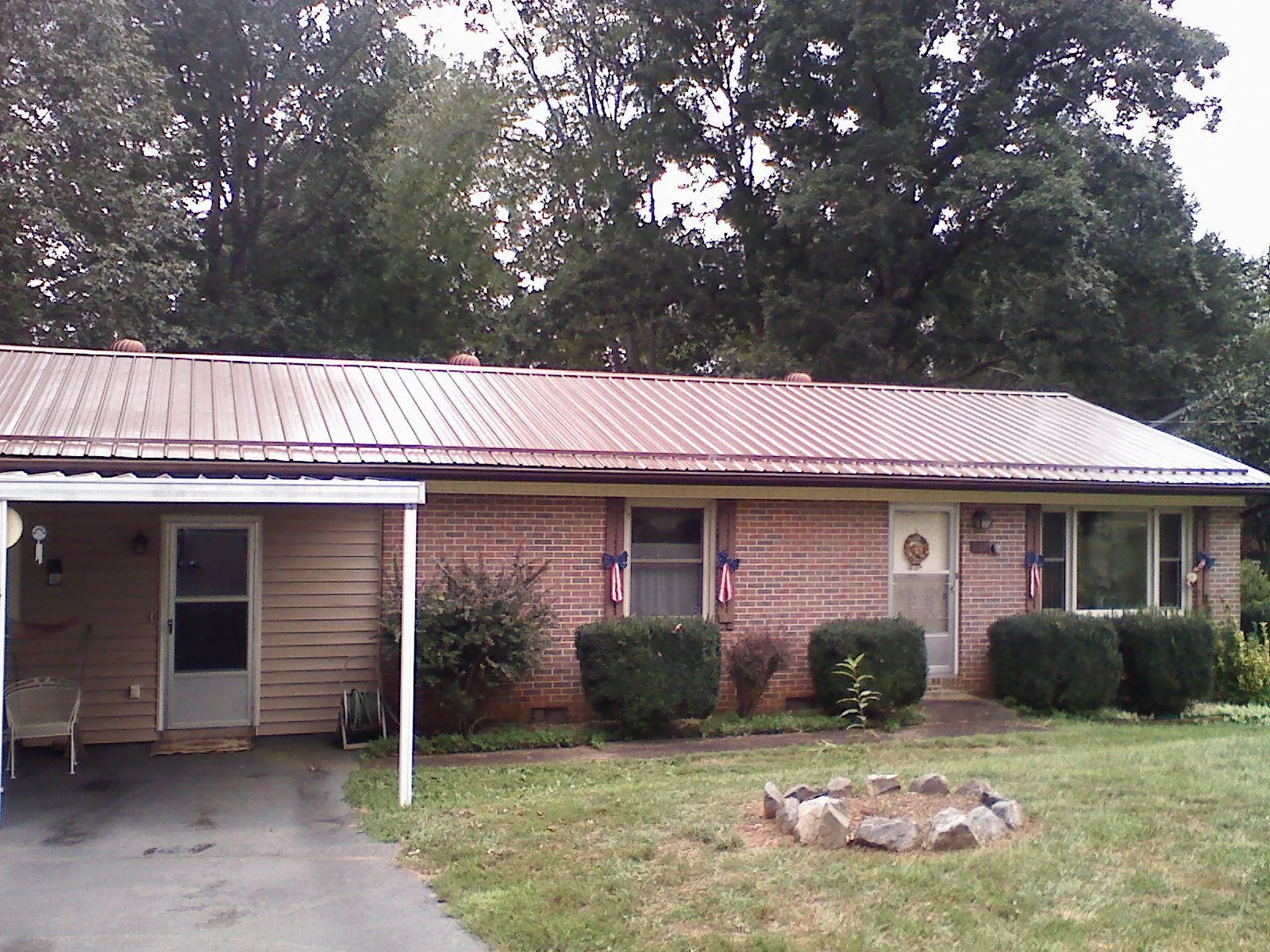Bronze metal roof and carport on a brick ranch home — Roof Repair work by our crew in Ozark